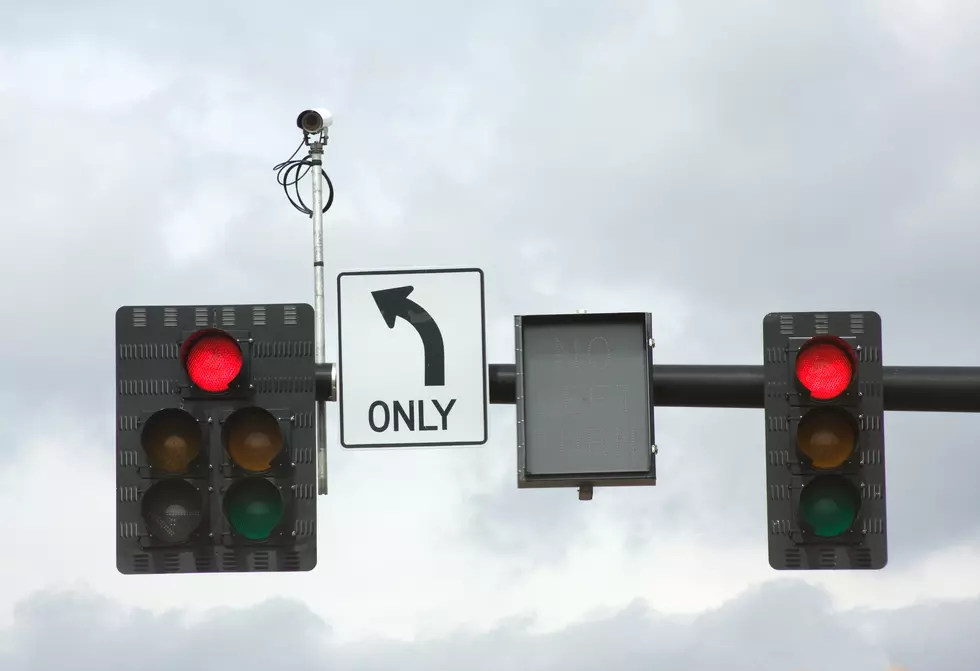 Traffic Signals and Camera Against a Cloudy Sky